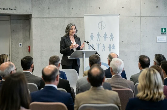 Femme militante prenant la parole lors d'une conférence sur les droits humains en France, incarnant un engagement citoyen et une vie dédiée aux causes humanitaires